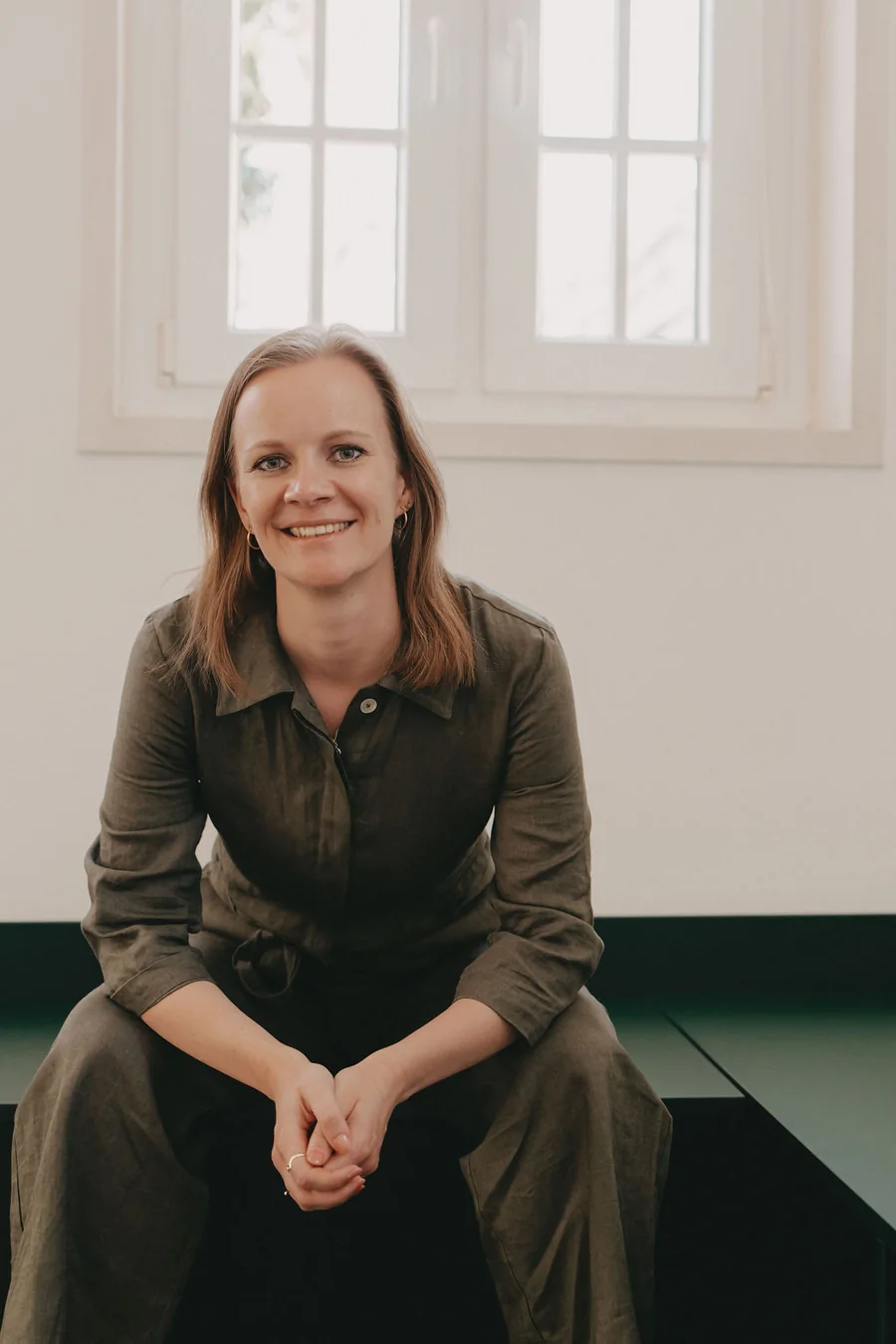 Yvonne Minohr, Virtuelle Assistentin, sitzt lächelnd in einem hellen Raum